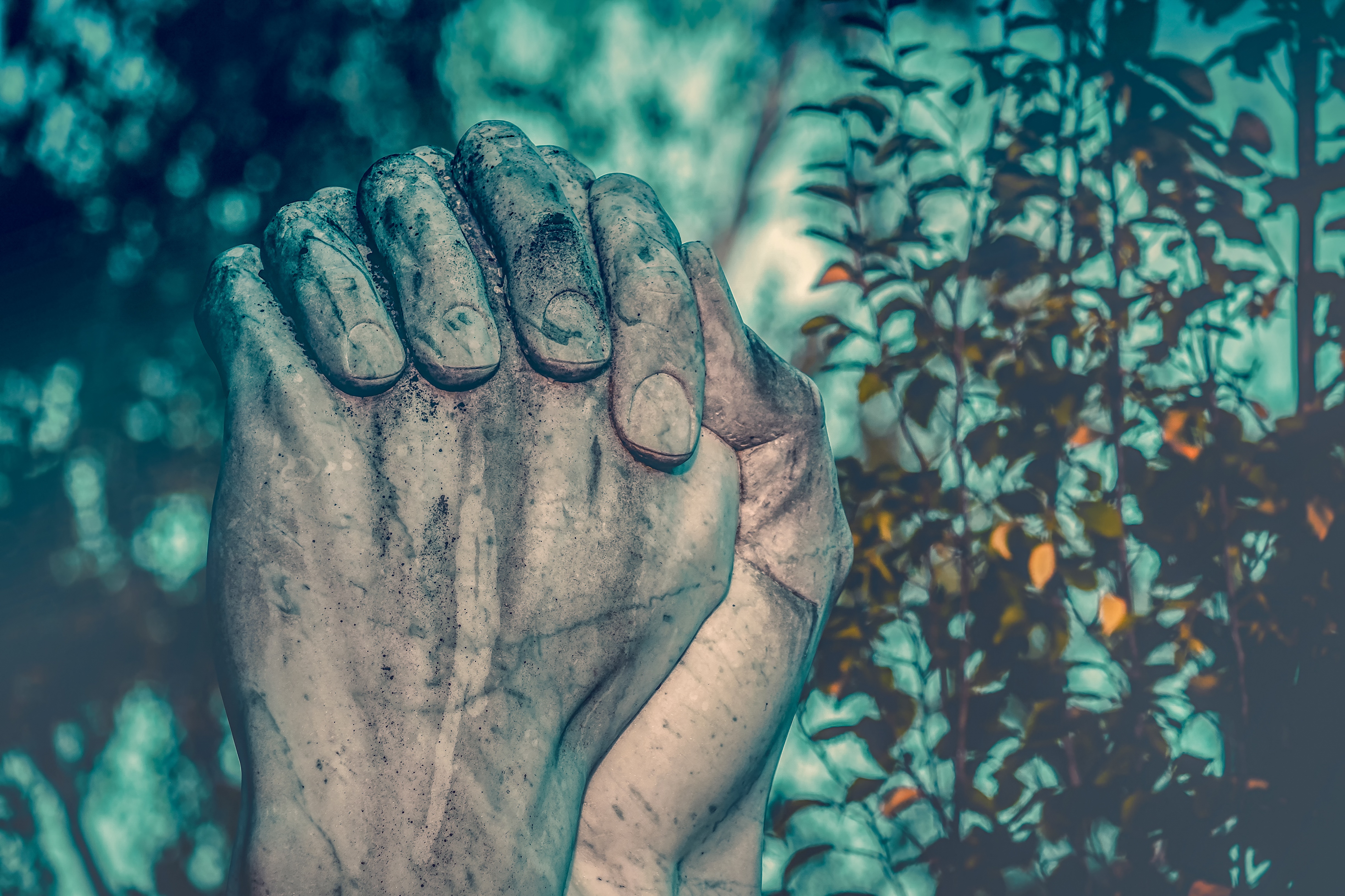 Image of hands praying from monument