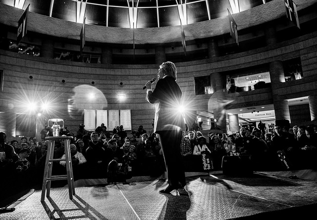 image of hillary clinton speaking on a stage - black and white