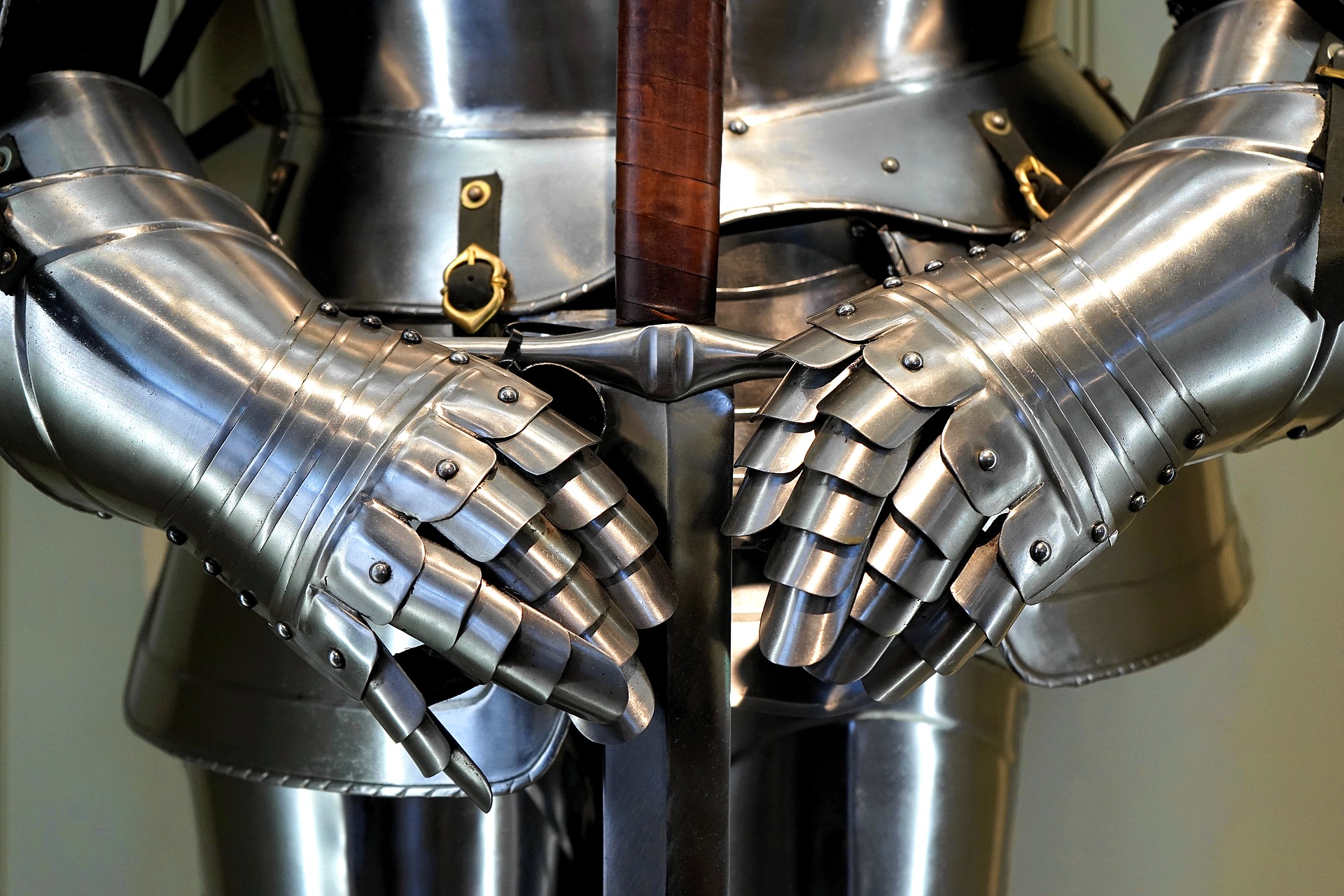 image of knight's armor with hands holding sword by groin